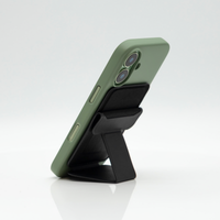 Black Peel Magnetic Wallet Stand propping a green-cased iPhone upright in portrait mode
